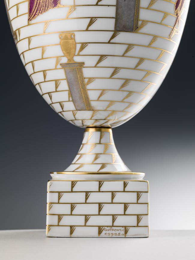 Dettaglio della base del vaso bianco con decori policromi e oro su fondo bianco