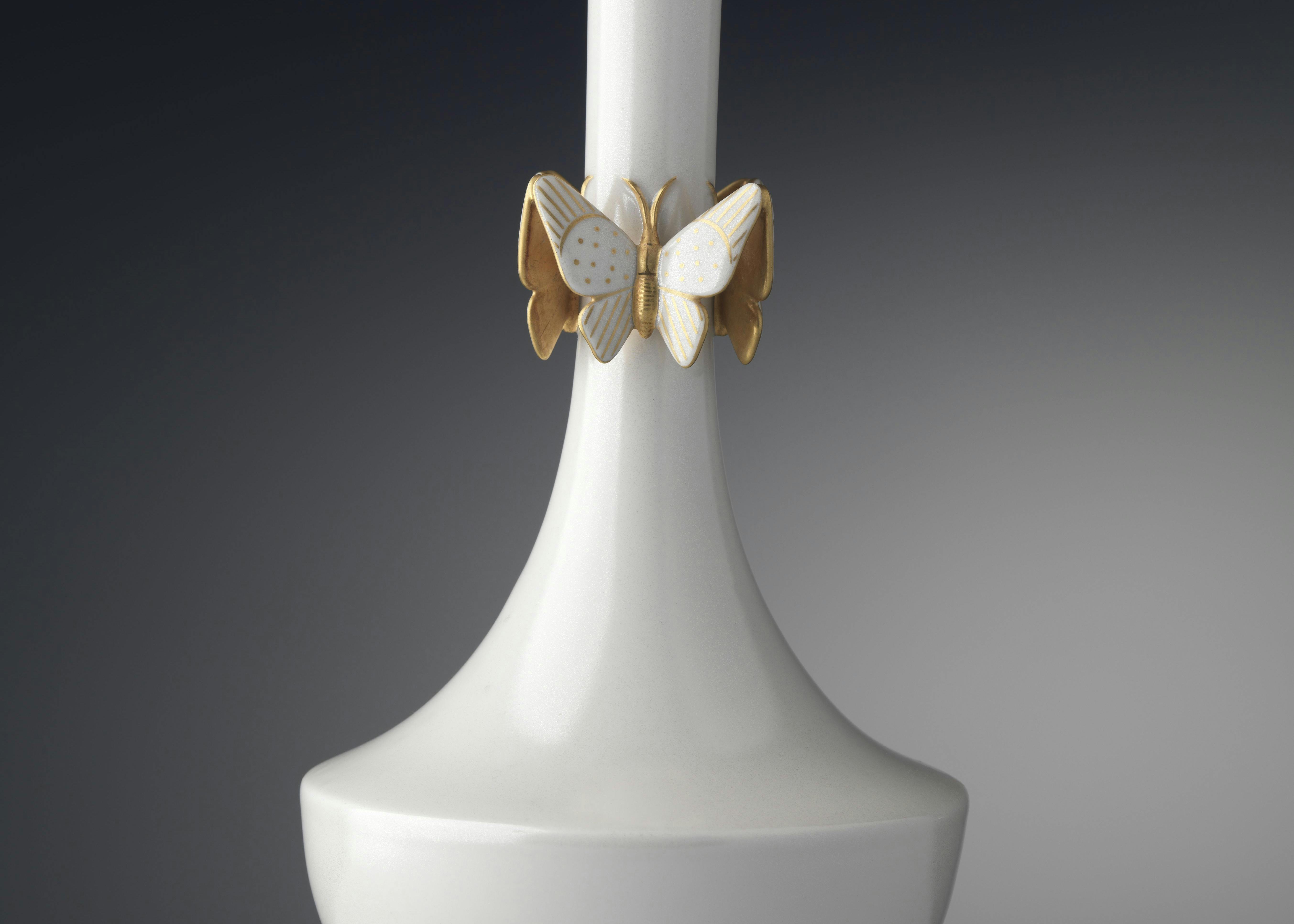 Vaso bianco con farfalle appoggiate sul lungo collo