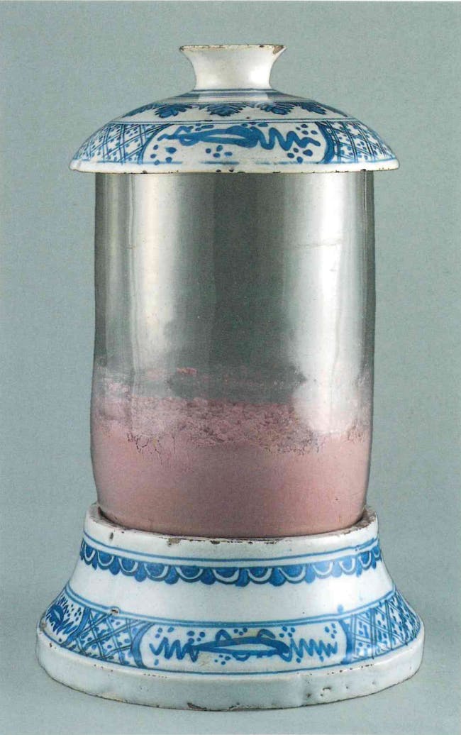 Vaso bianco e blu di porcellana e vetro contenente polvere rosa