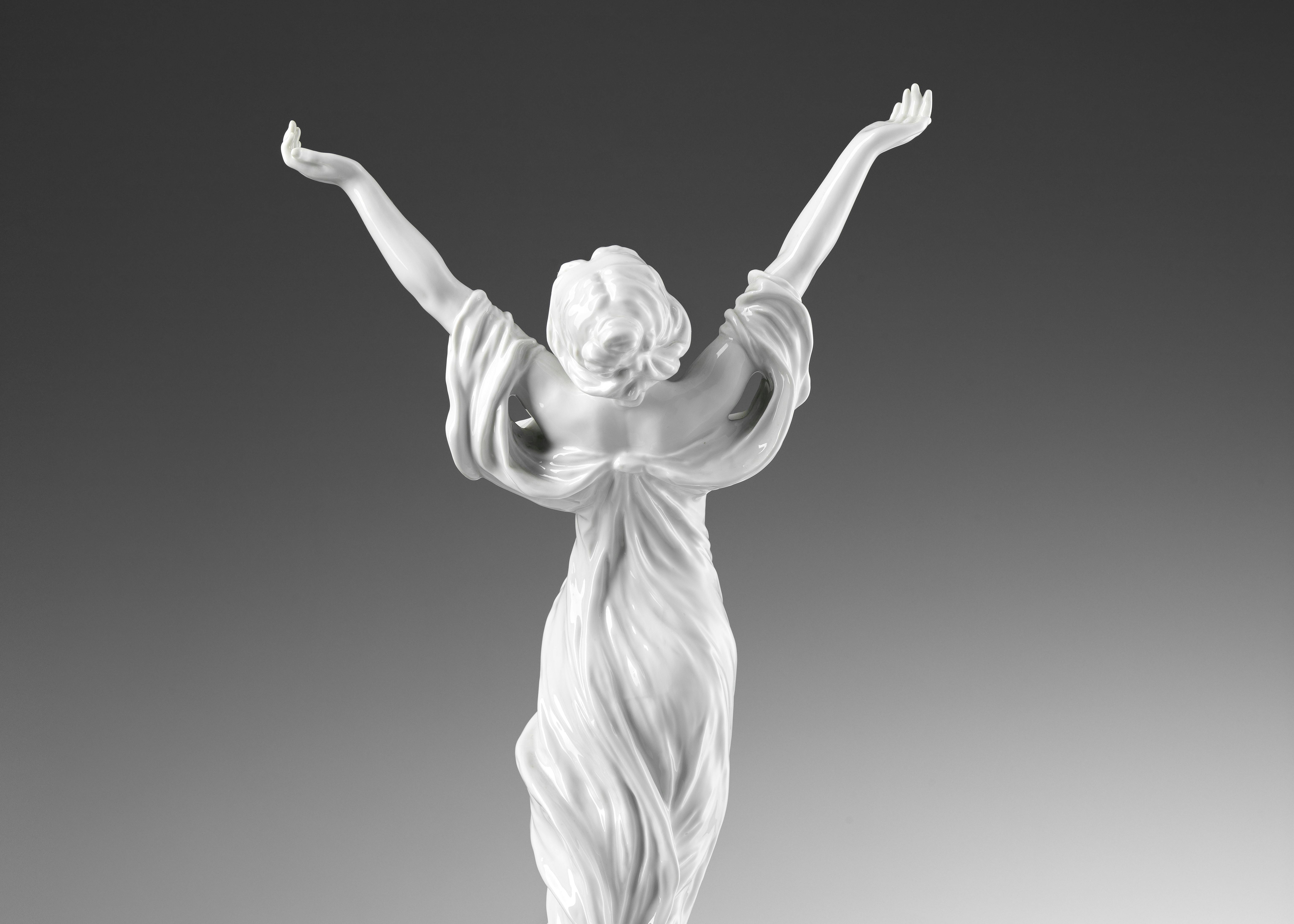 Retro della statua che raffigura una figura femminile a braccia alzate, coperta da un abito leggero mosso dal vento
