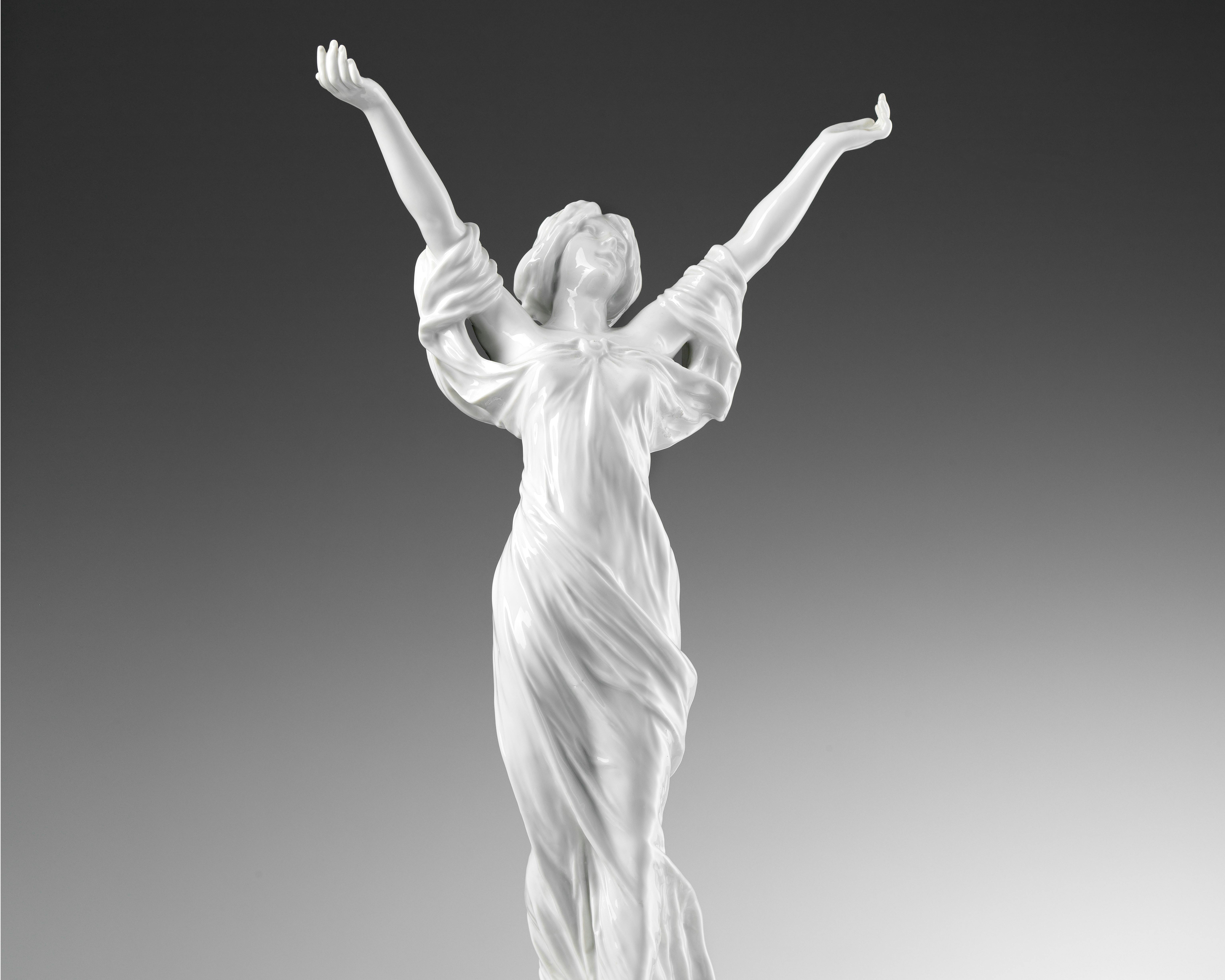 La scultura raffigura una donna a braccia aperte con una veste leggera mossa dal vento