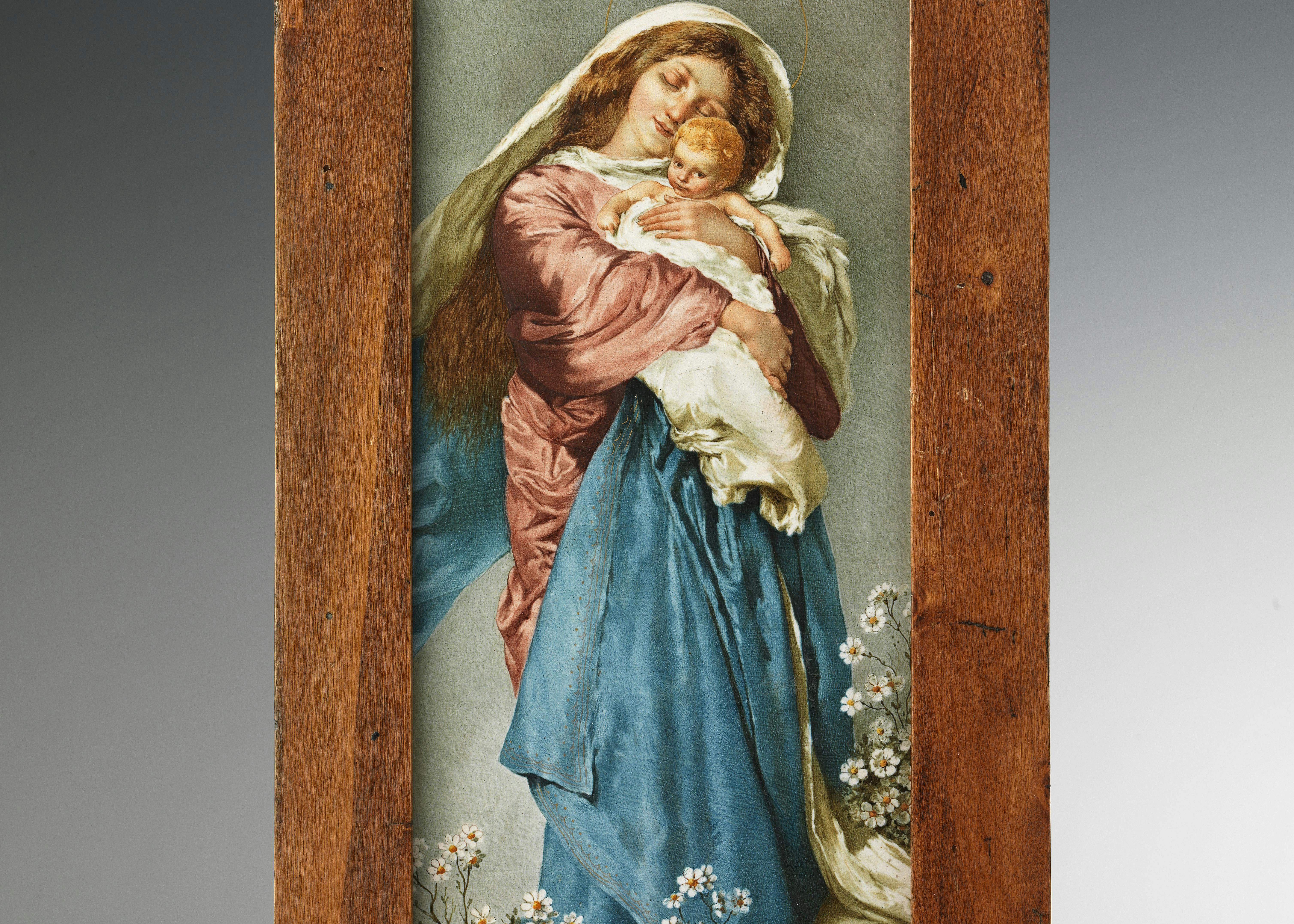 La lastra rappresenta una Madonna con biti rosa e azzurri che stringe al petto il bambino