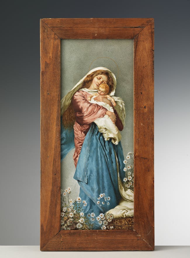 La lastra rappresenta una Madonna con biti rosa e azzurri che stringe al petto il bambino