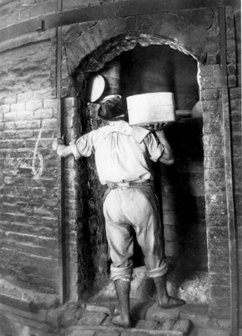 Un operaio di spalle sulla porta del forno
