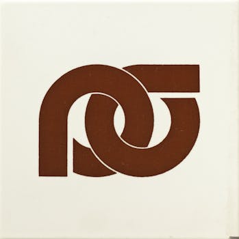 Piastrella bianca con al centro le lettere P e G in marrone