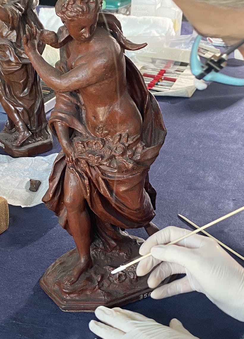Una restauratrice lavora su una scultura in cera