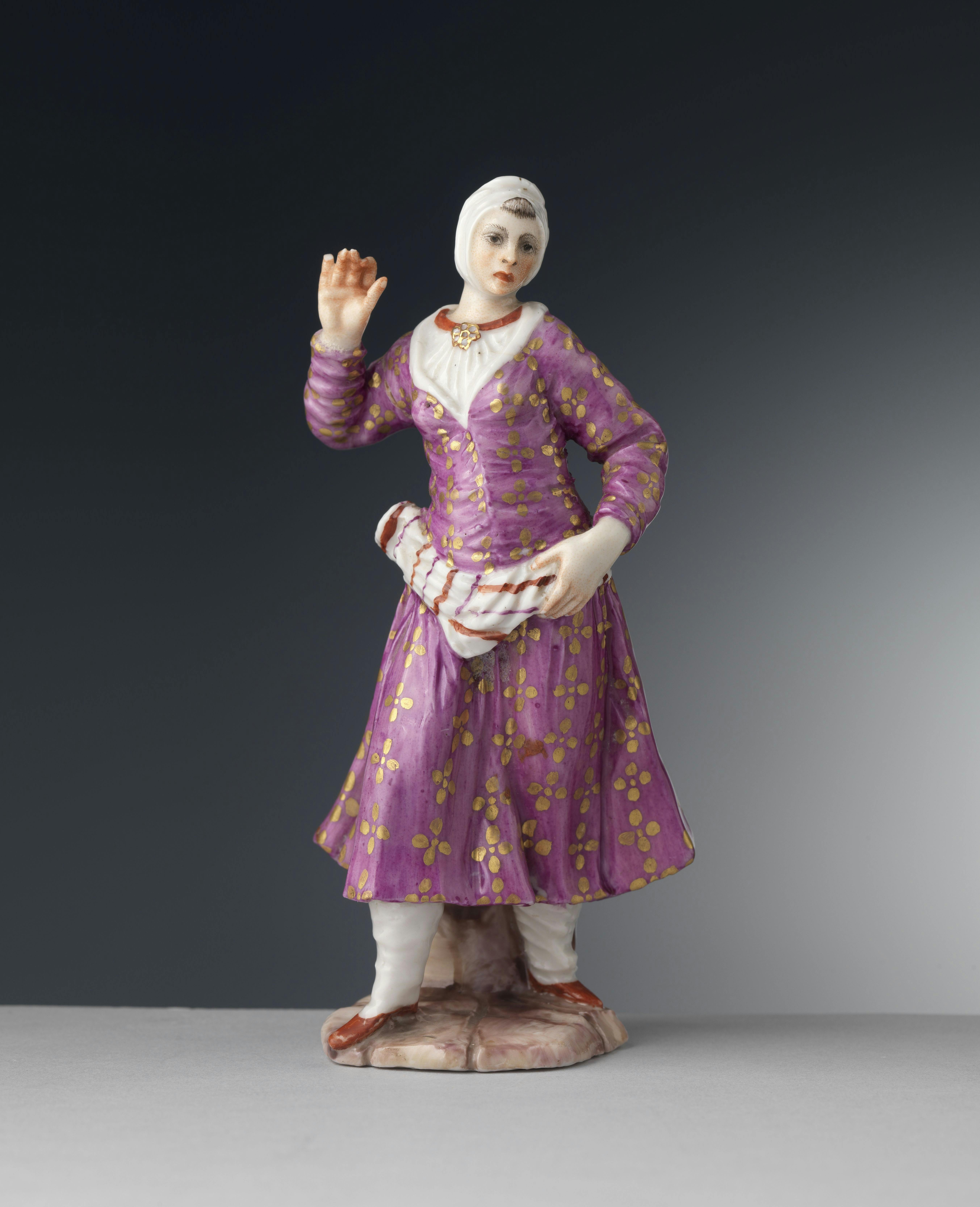 Figura femminile con abito rosa e oro e calzari orientaleggianti