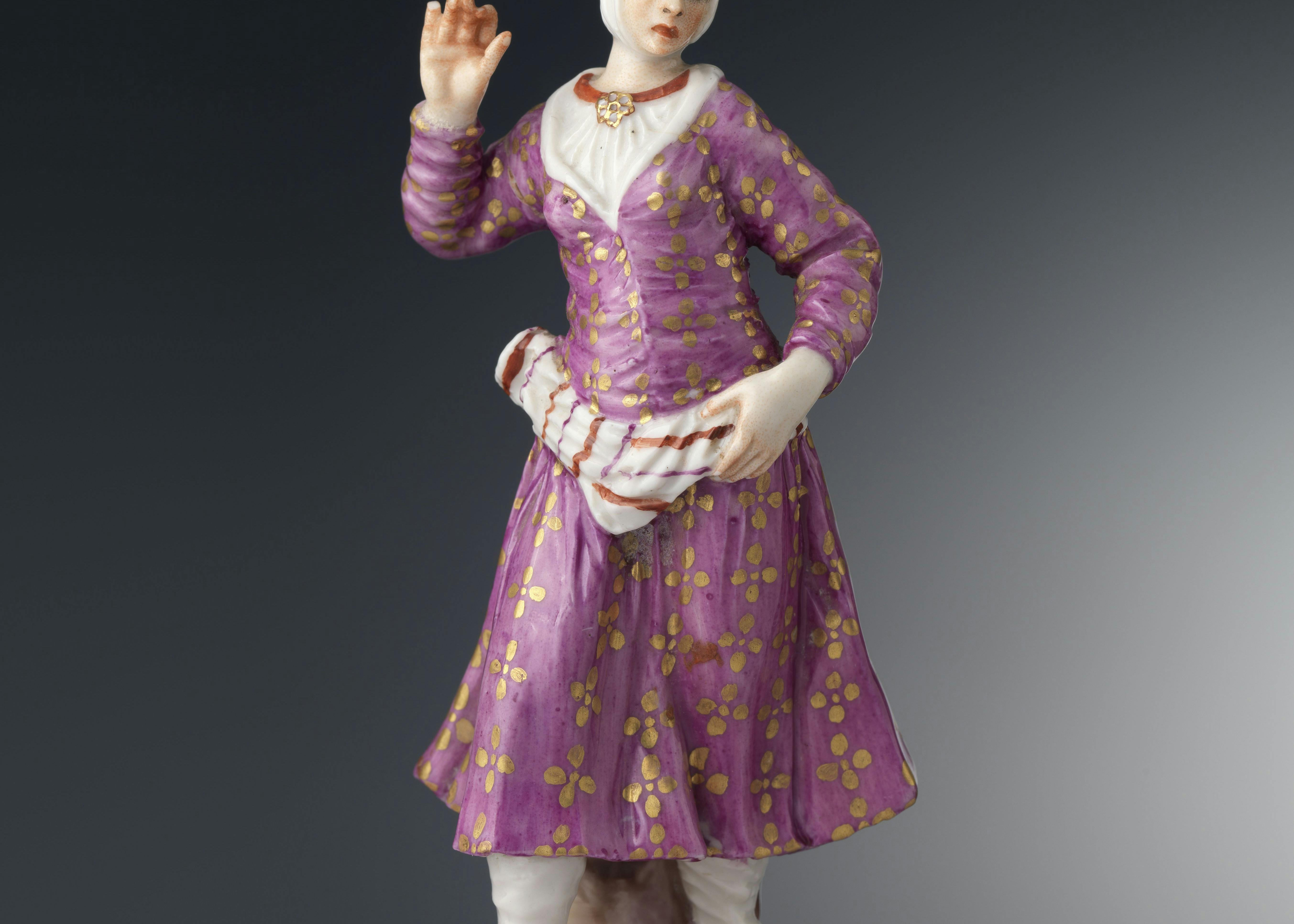 Figura femminile con abito rosa e oro e calzari orientaleggianti