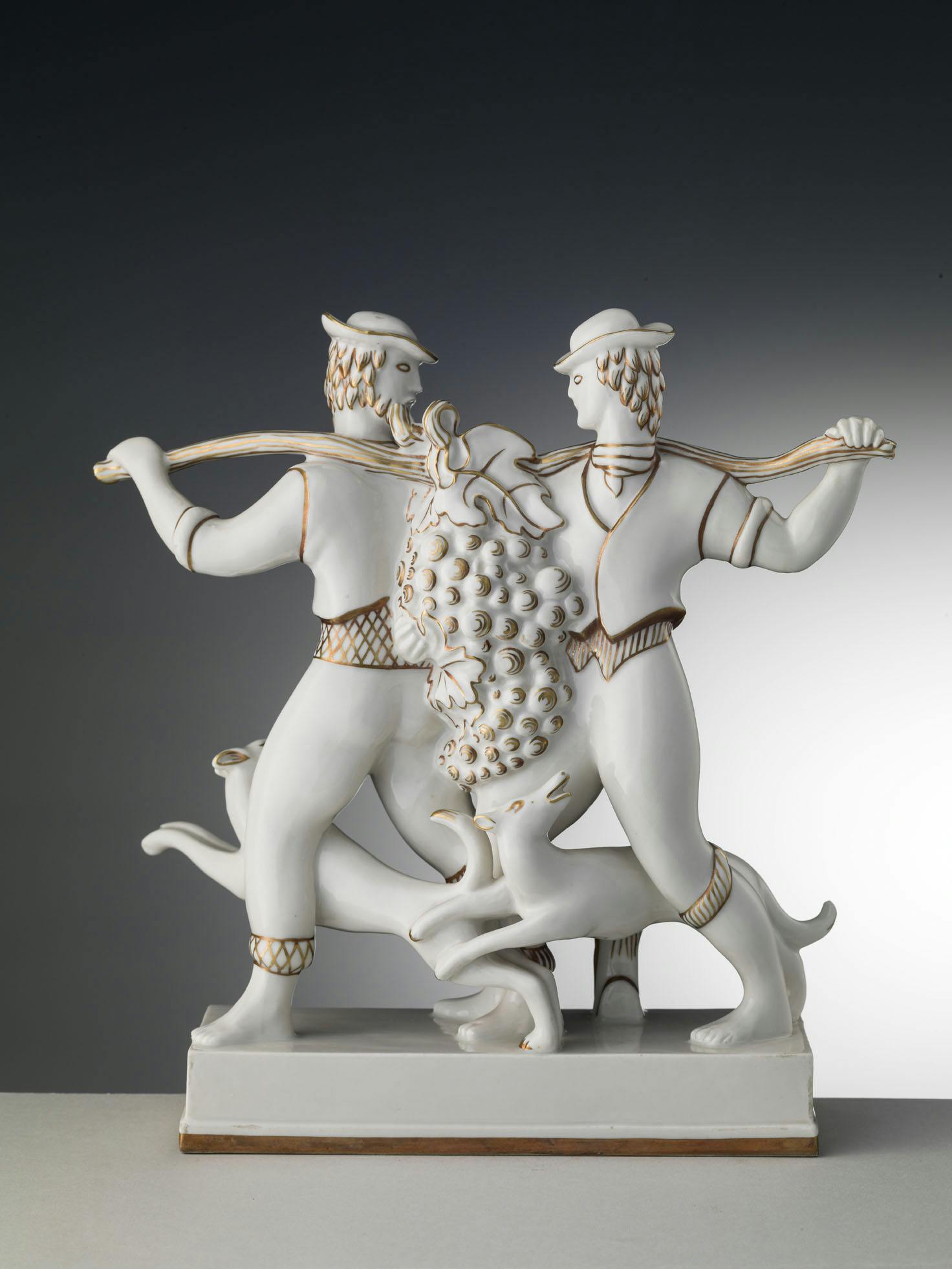 Gruppo scultoreo bianco e oro con due figure che sostengono un tralcio di vite