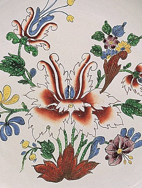Dettaglio del decoro con fiori variopinti su fondo bianco