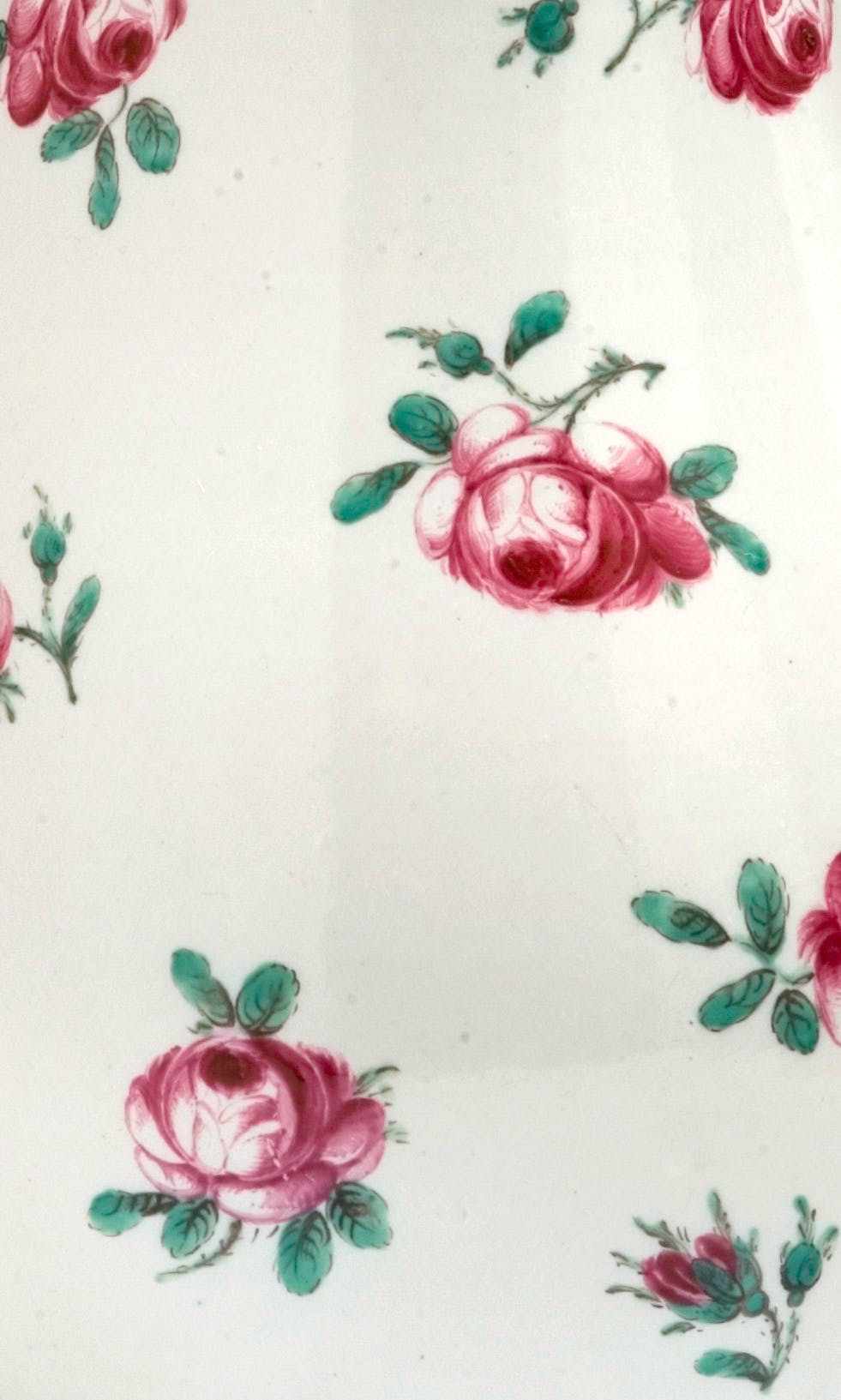 Dettaglio del decoro con piccole rose rosa e foglie verdi su fondo bianco