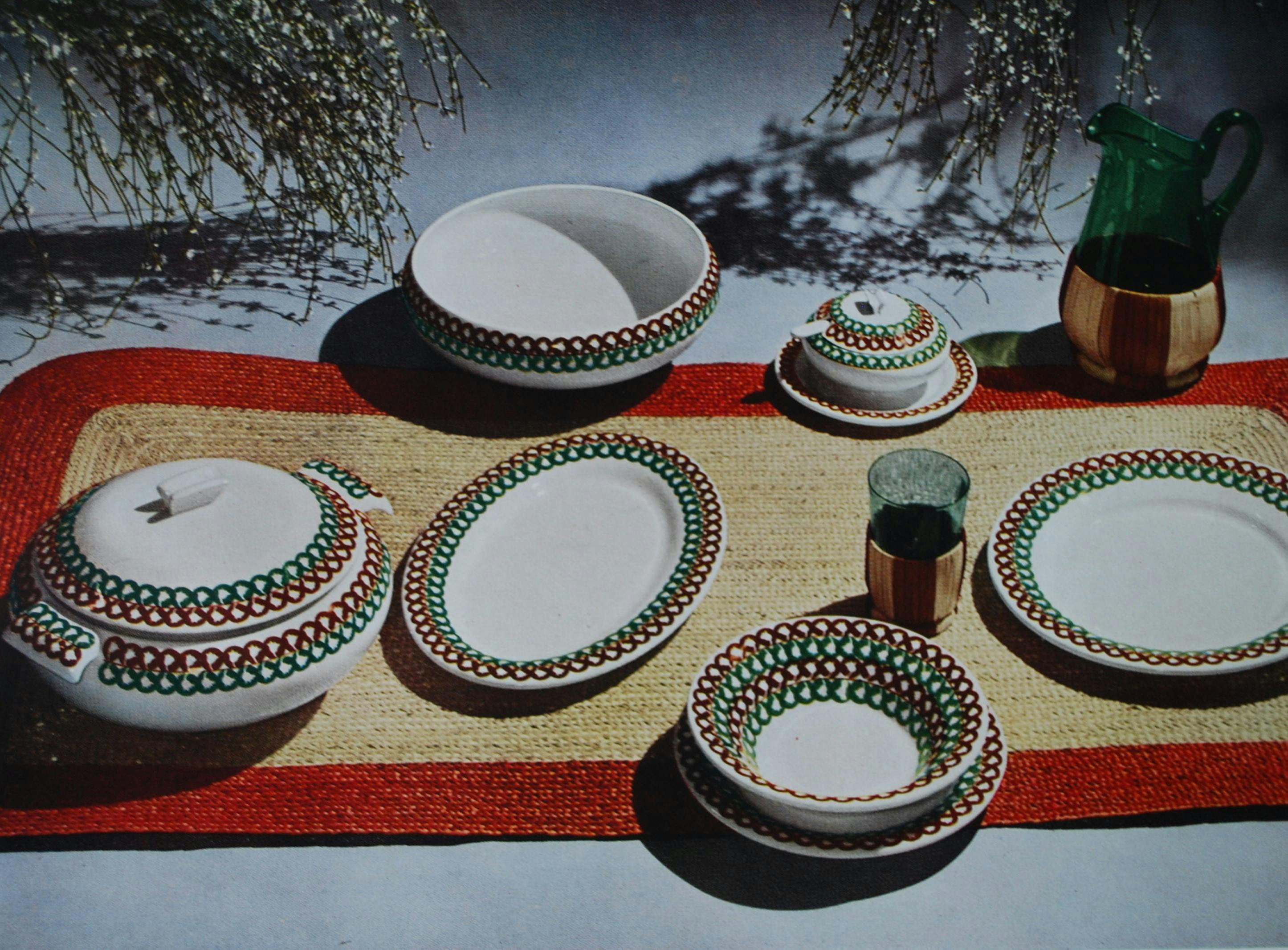 Foto di una tavola apparecchiata con stoviglie dal bordo decorato a più colori