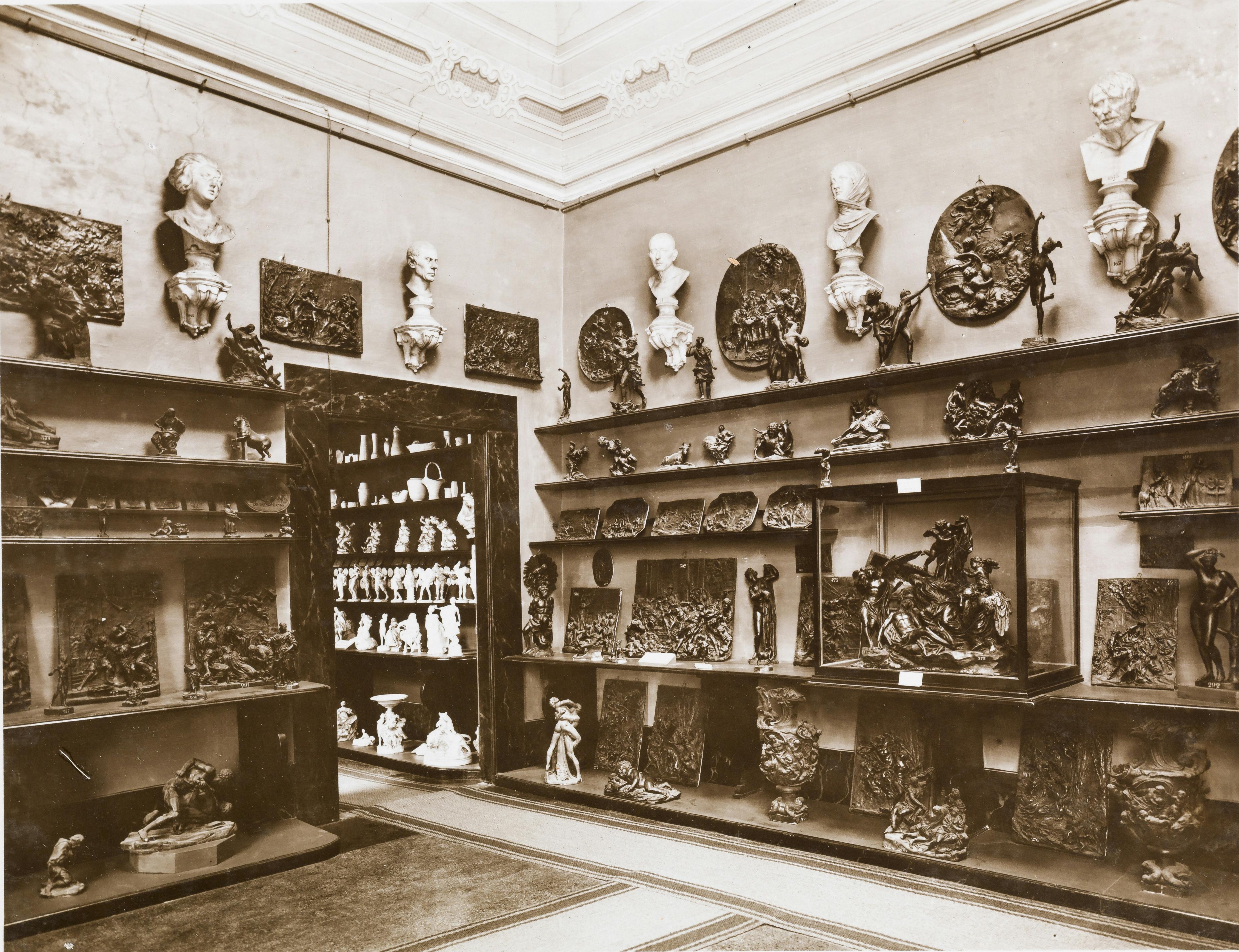 foto in bianco e nero di una sala con pareti colme di modelli scultorei in cera