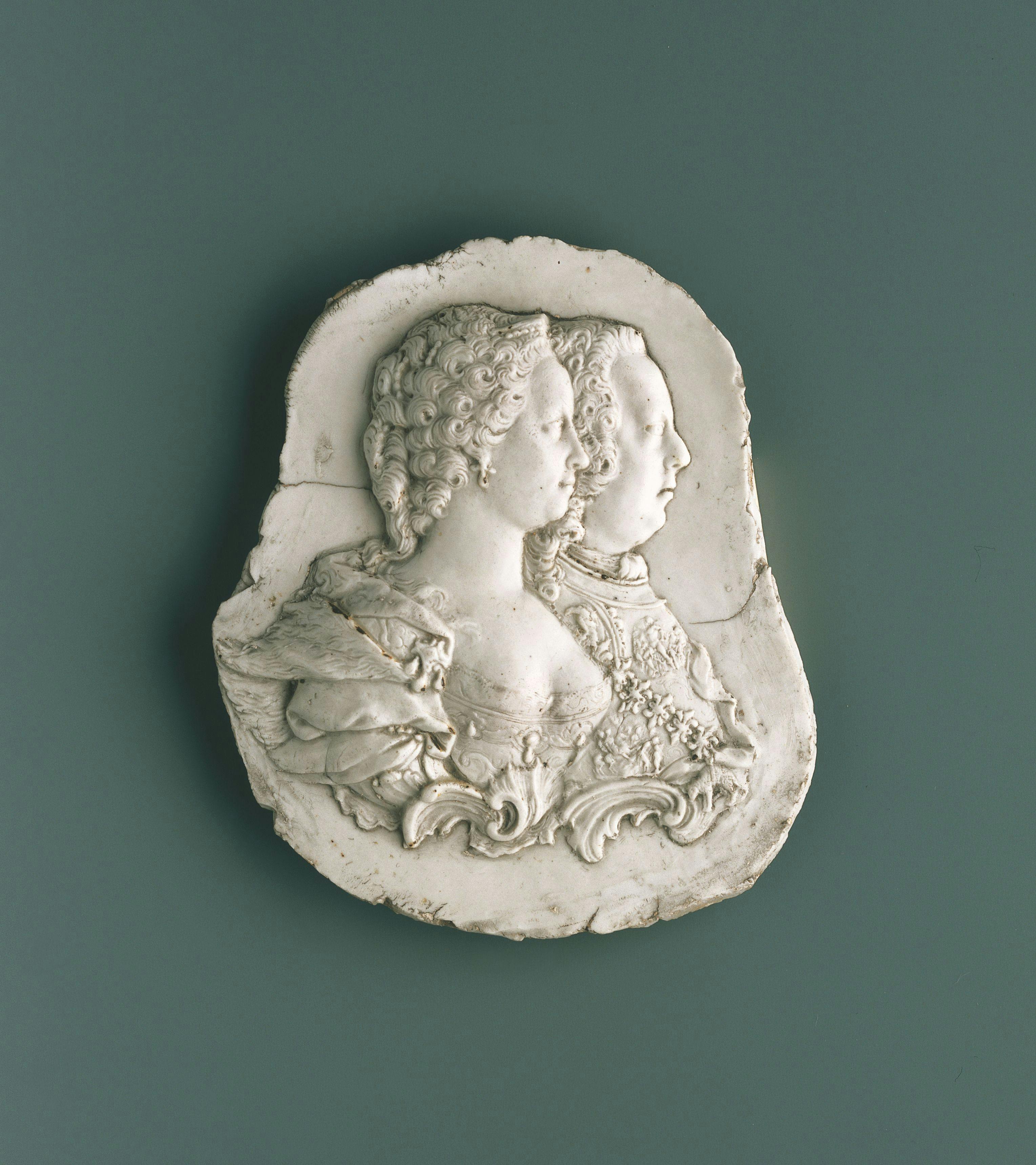 Placca bianca con busto maschile e busto femminile di profilo