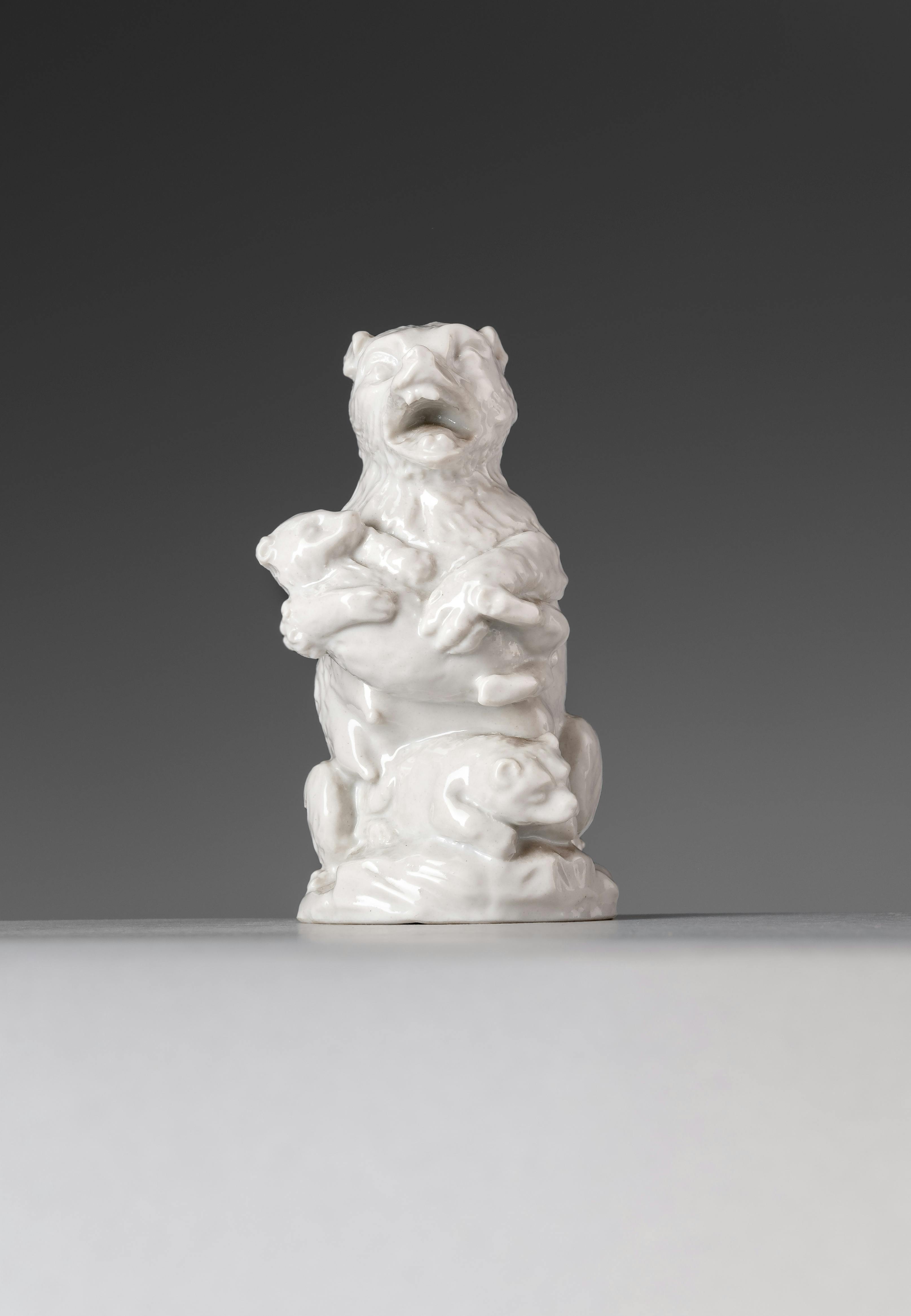 Statuina in porcellana bianca raffigurante un orsa con un cucciolo in braccio e un altro cucciolo ai suoi piedi
