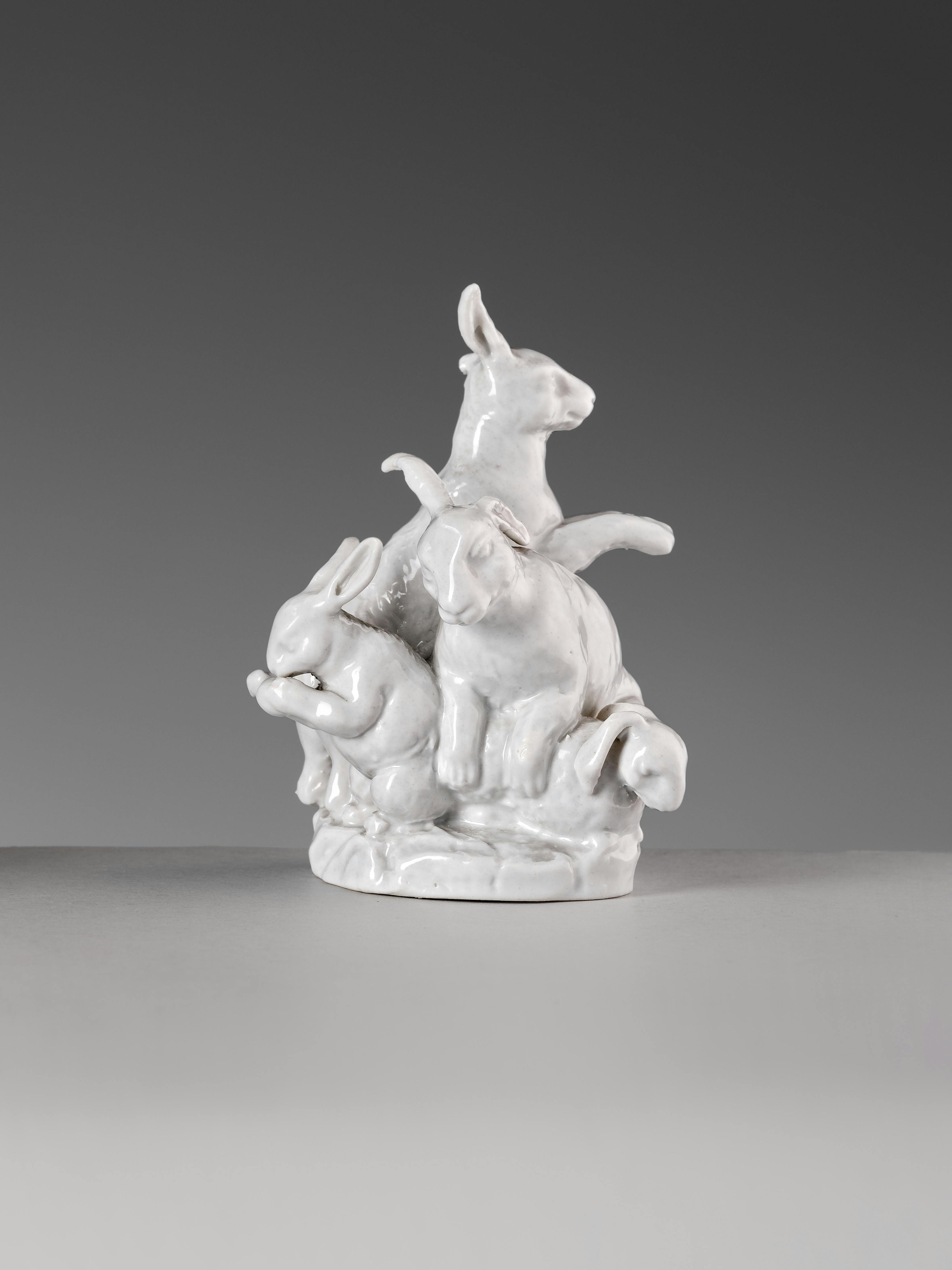 Scultura in porcellana bianca raffigurante 4 conigli su una base circolare