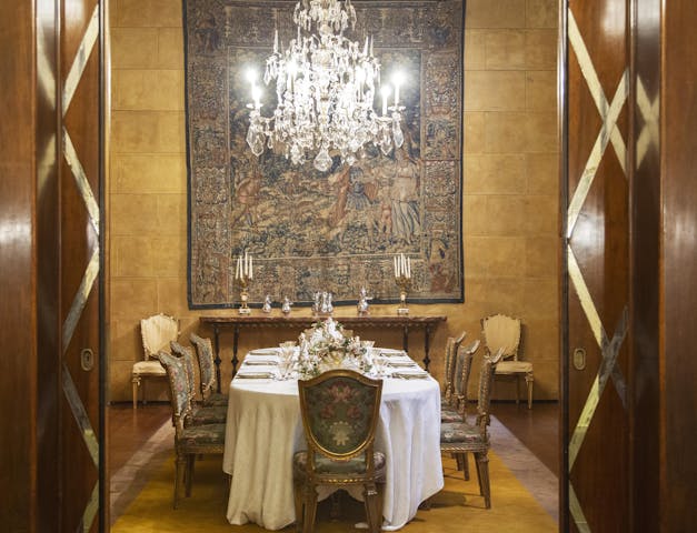 Vista complessiva della sala da pranzo con tavolo apparecchiato