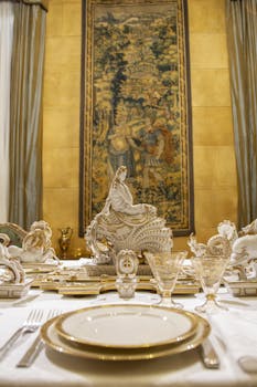 Un posto tavola apparecchiato con sullo sfondo una statua bianca e oro