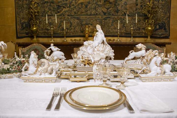 Vista della parte centrale del tavolo decorato con un centrotavola bianco e oro