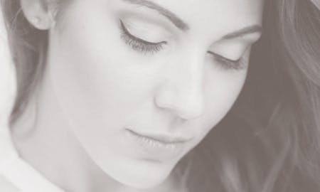 Beautiful woman's face, looking down, showcasing results of eyelid surgery in Nashville