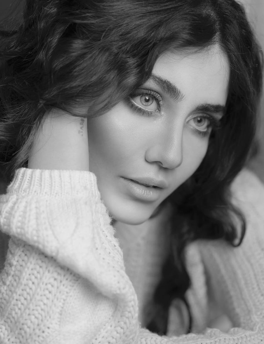 Closeup of a woman with her arm against her face.