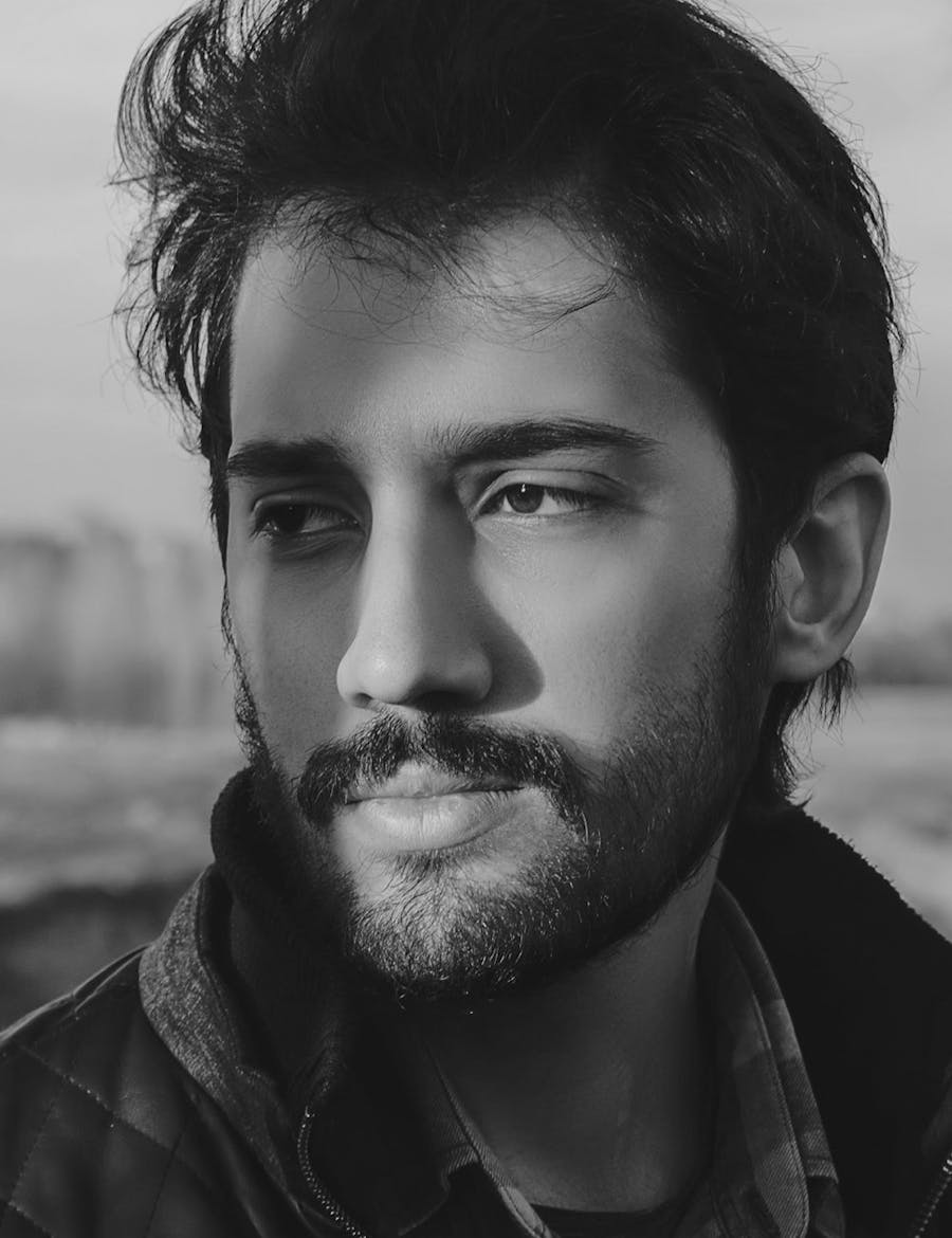 A man in shadows looking off to the side.