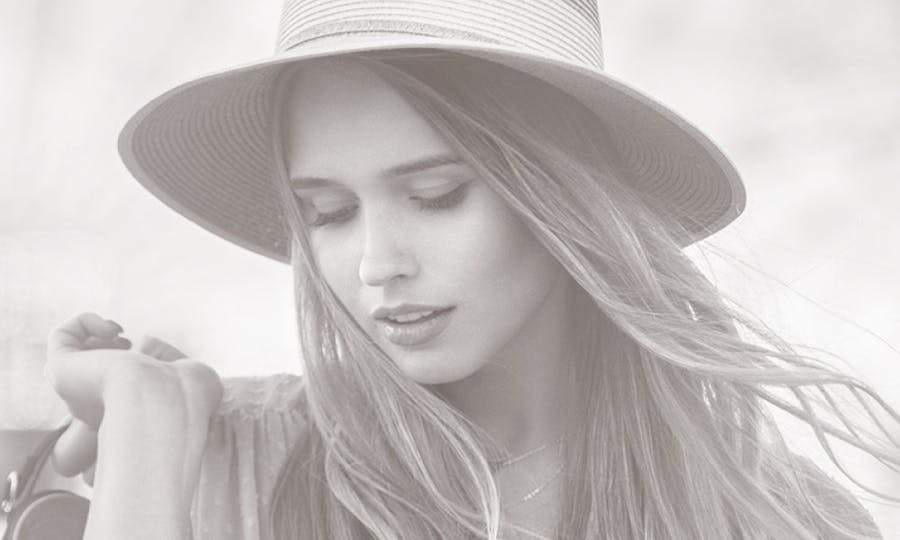 Woman in a brimmed hat looking down.
