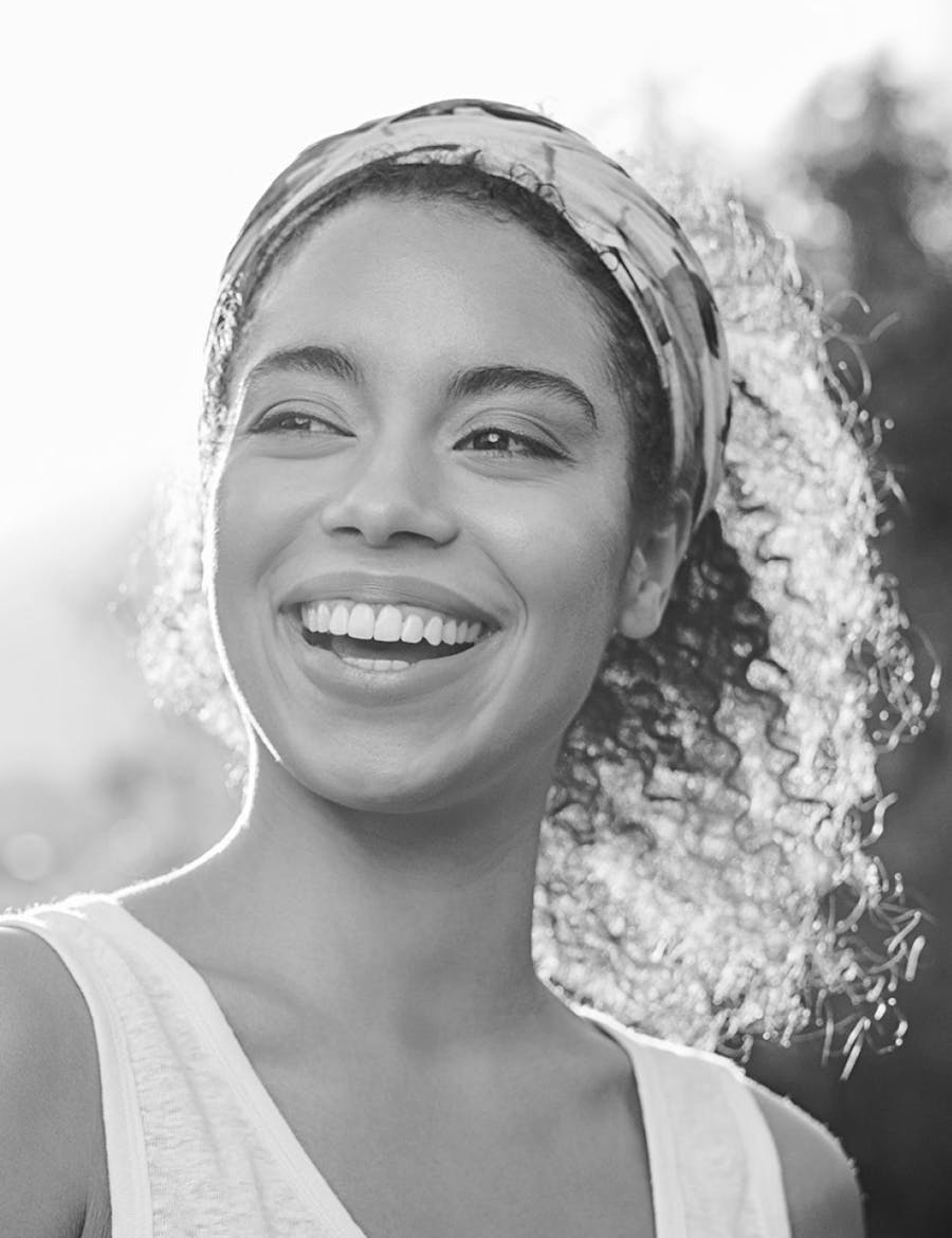 Beautiful, smiling woman with the sun to her back.