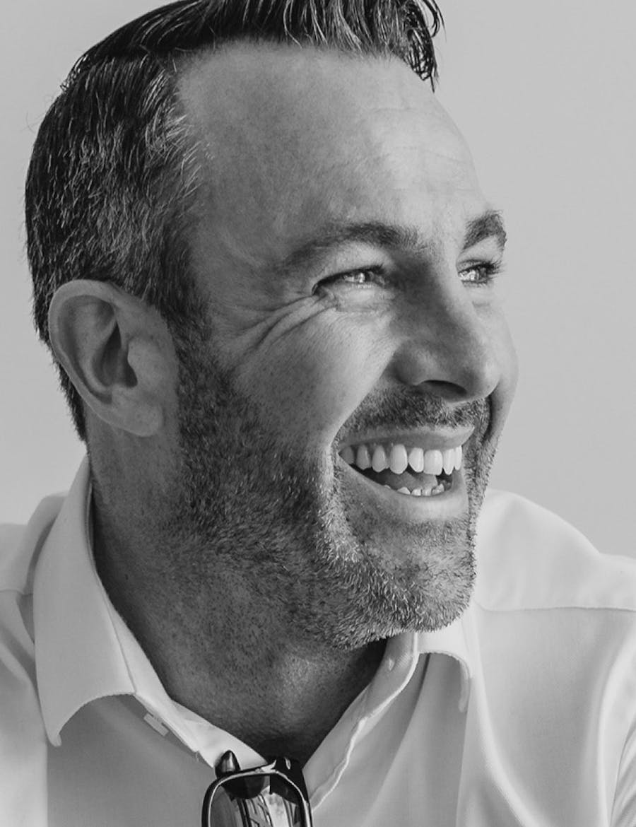 Stubbled man looking to the side and smiling.