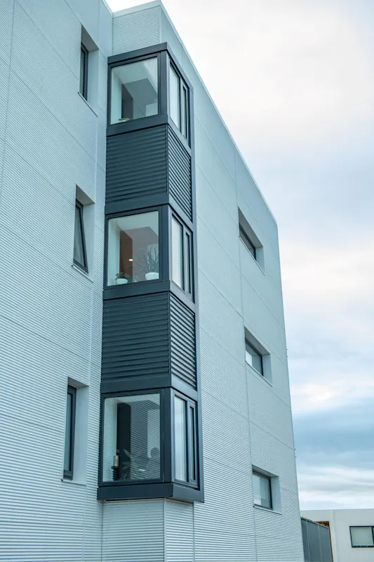 Horngluggar úr timbri í fjölbýlishúsi