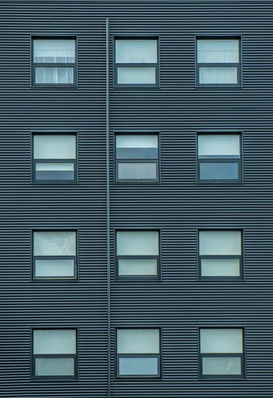 Gluggar í álklæddu fjölbýlishúsi