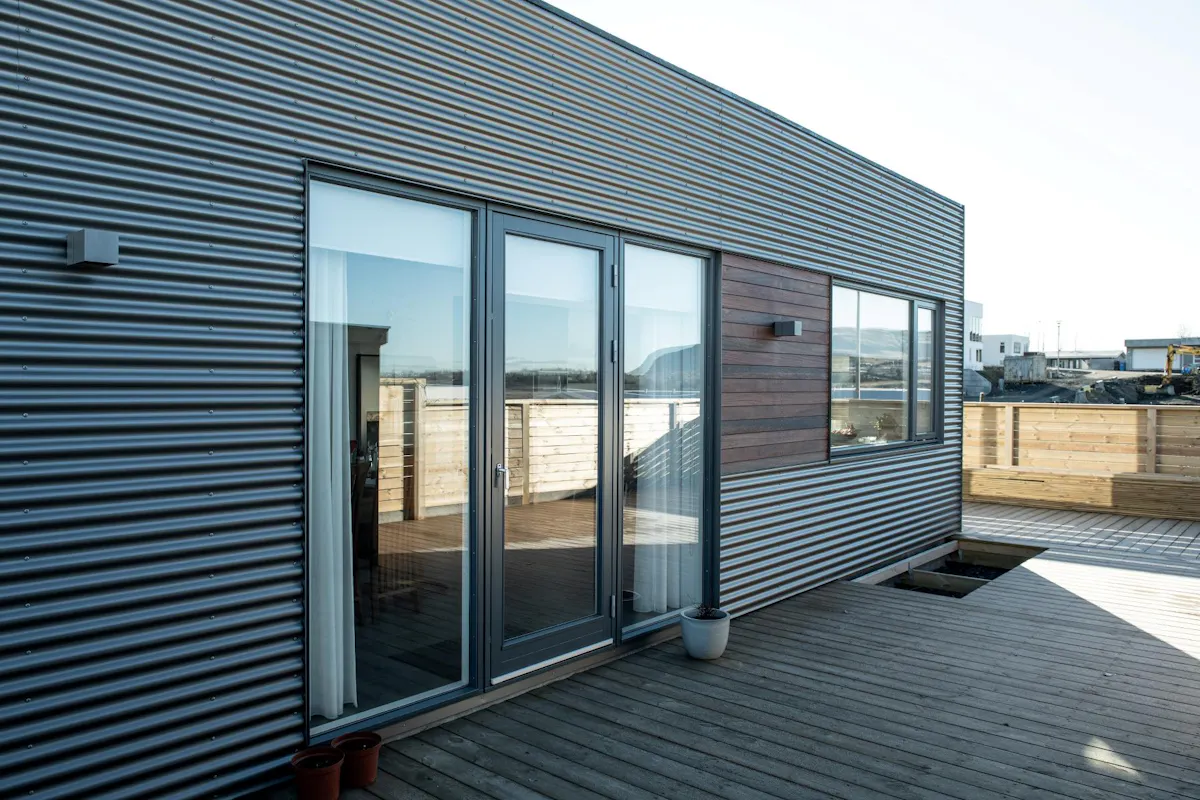 Bárujárnsklætt einbýlishús með timburgluggum