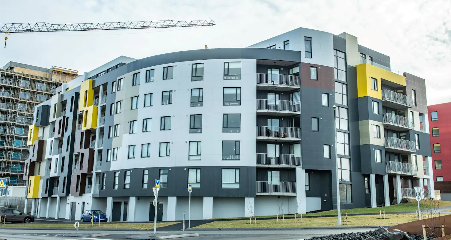 Álklæddir viðargluggar í fjölbýlishúsi í Reykjavík