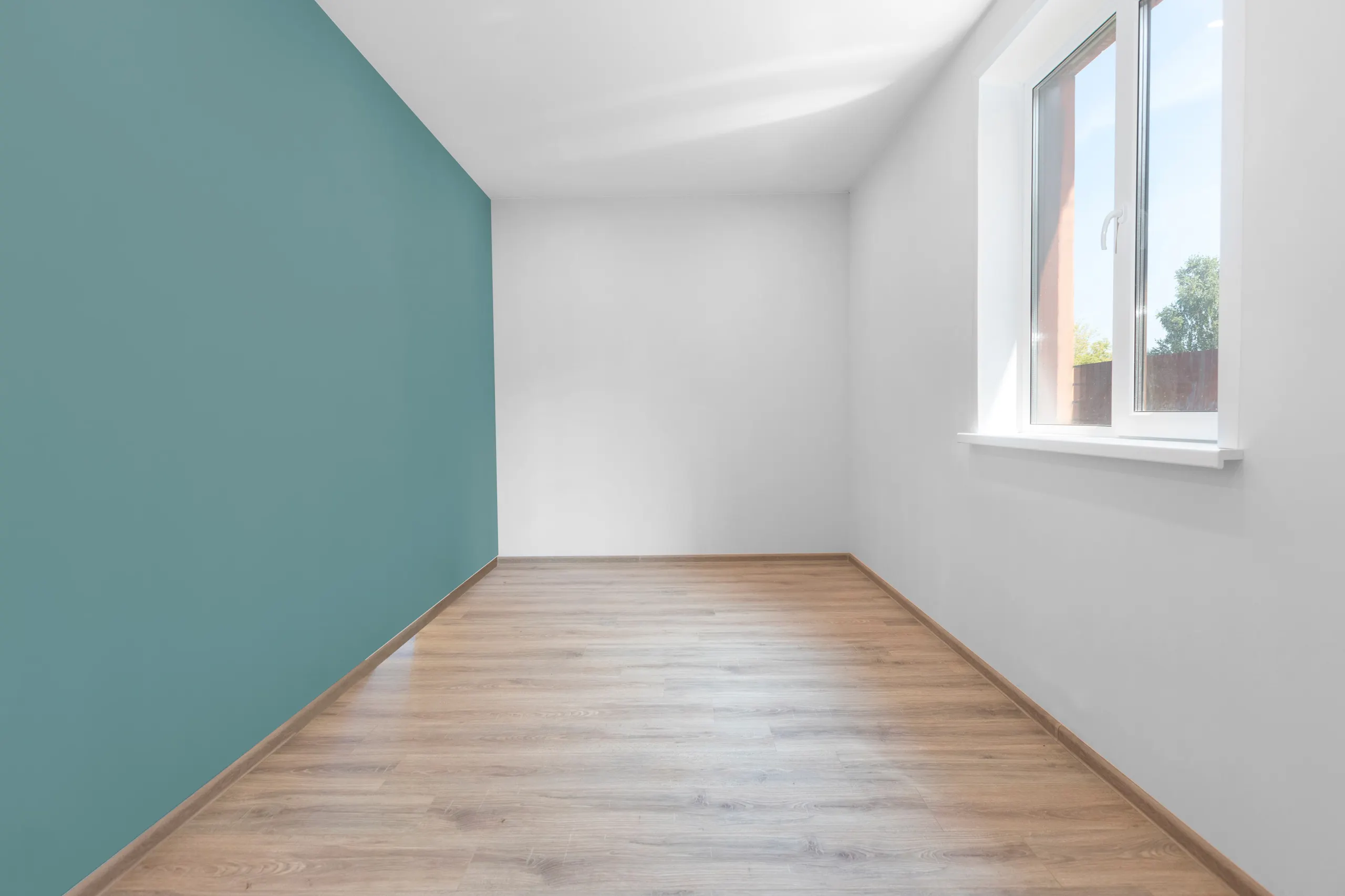 Einn stakur veggur í herbergi málaður í sægrænum lit