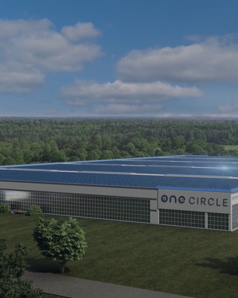 Animated aerial view of ONE Circle gigafactory with trees and pond in the background