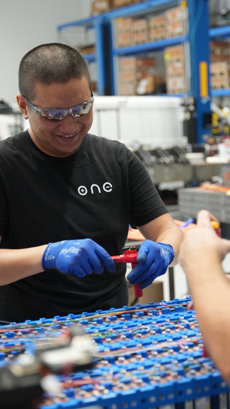 Two workers assembling battery packs on production line