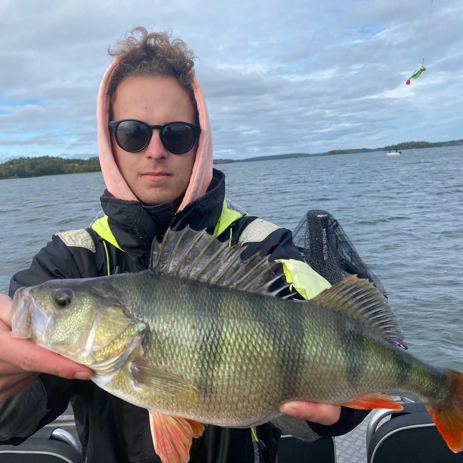 An image of Nathanael van den Berg, Technical Designer for Call of the Wild: The Angler having successfully caught a fish on a boat.