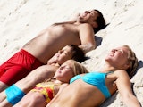 zonnen gezin zont op het strand