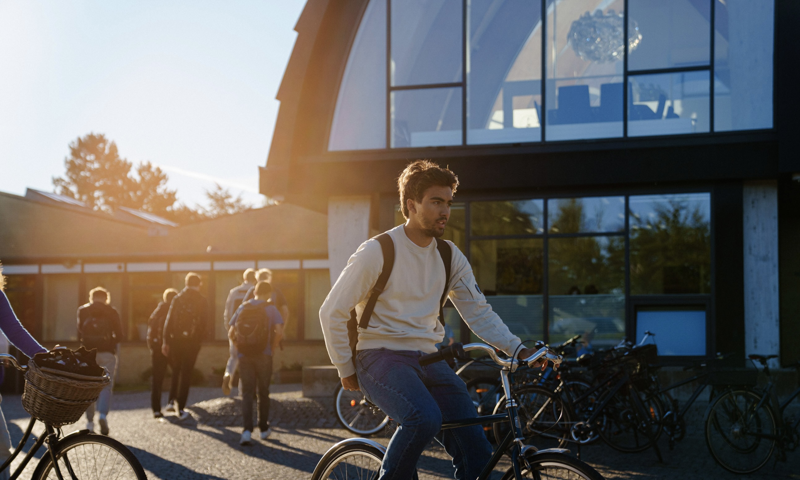 Elever fra Birkerød Gymnasium der cykler foran hovedindgangen til BG