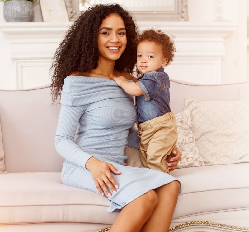 Smiling mother with curly hair & her baby.