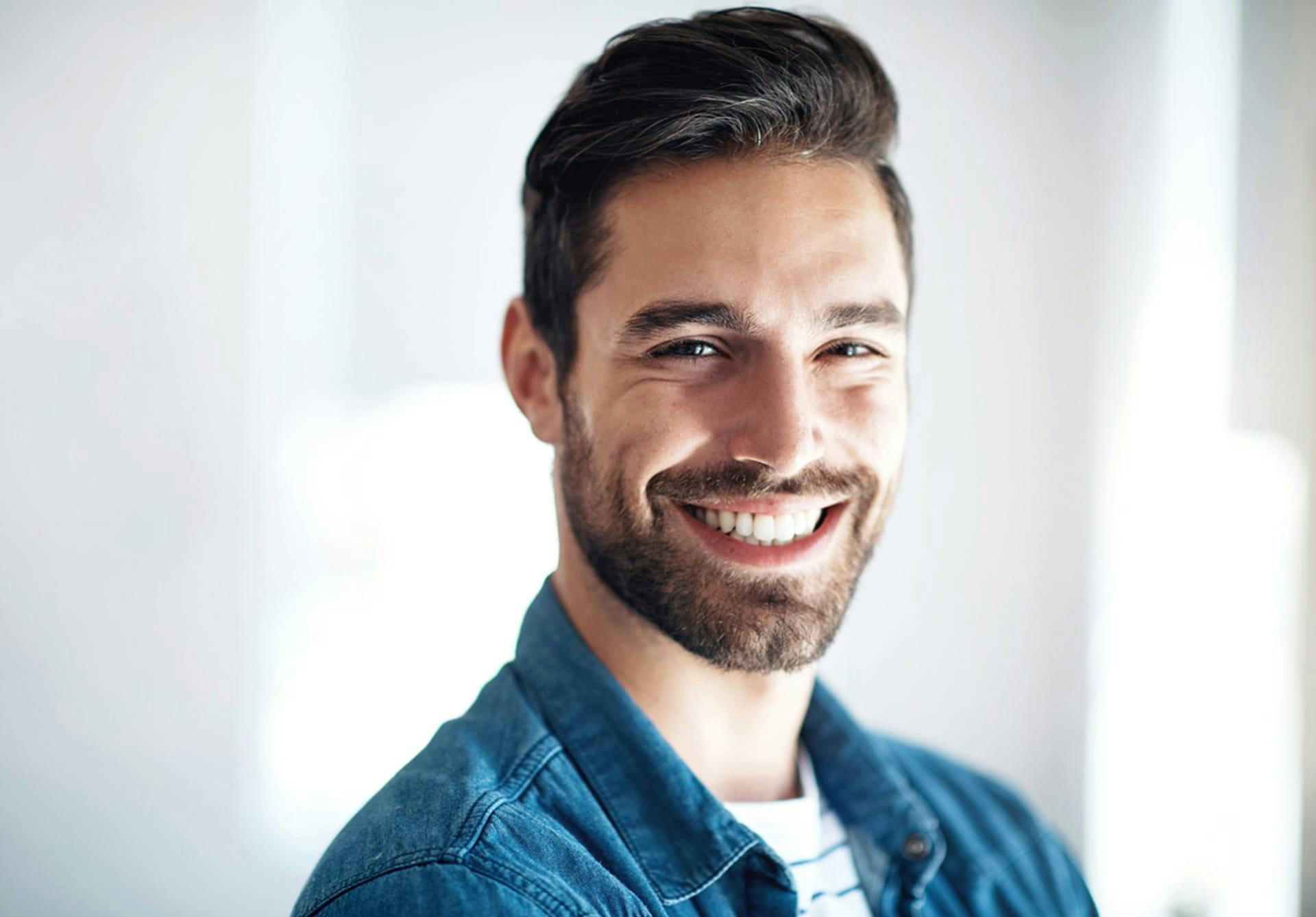 Smiling man with brown hair and blue jacket.