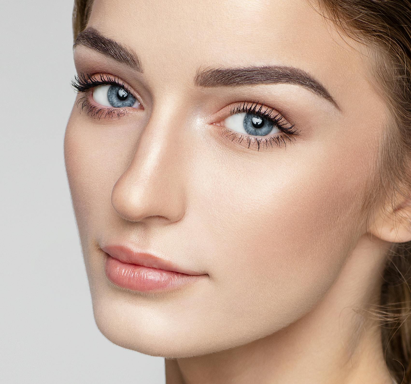Woman with perfect eyebrows looking towards the camera.