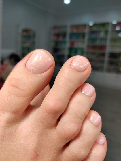 Nude glossy pedicure with a pearly sheen
