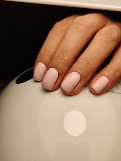 Pale pink manicure with a perfect highlight on short nails