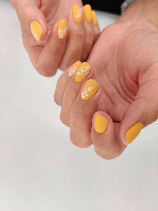 Nails in warm yellow tones with floral design