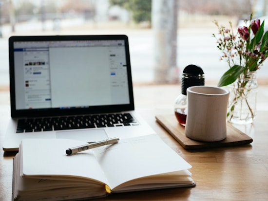 laptop with notebook and pen on a desk