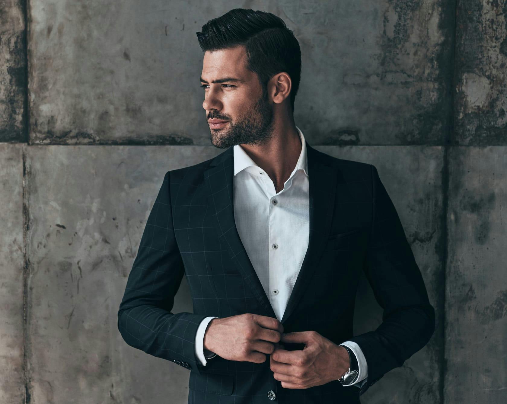 an image of a man in a suit next to a concrete wall