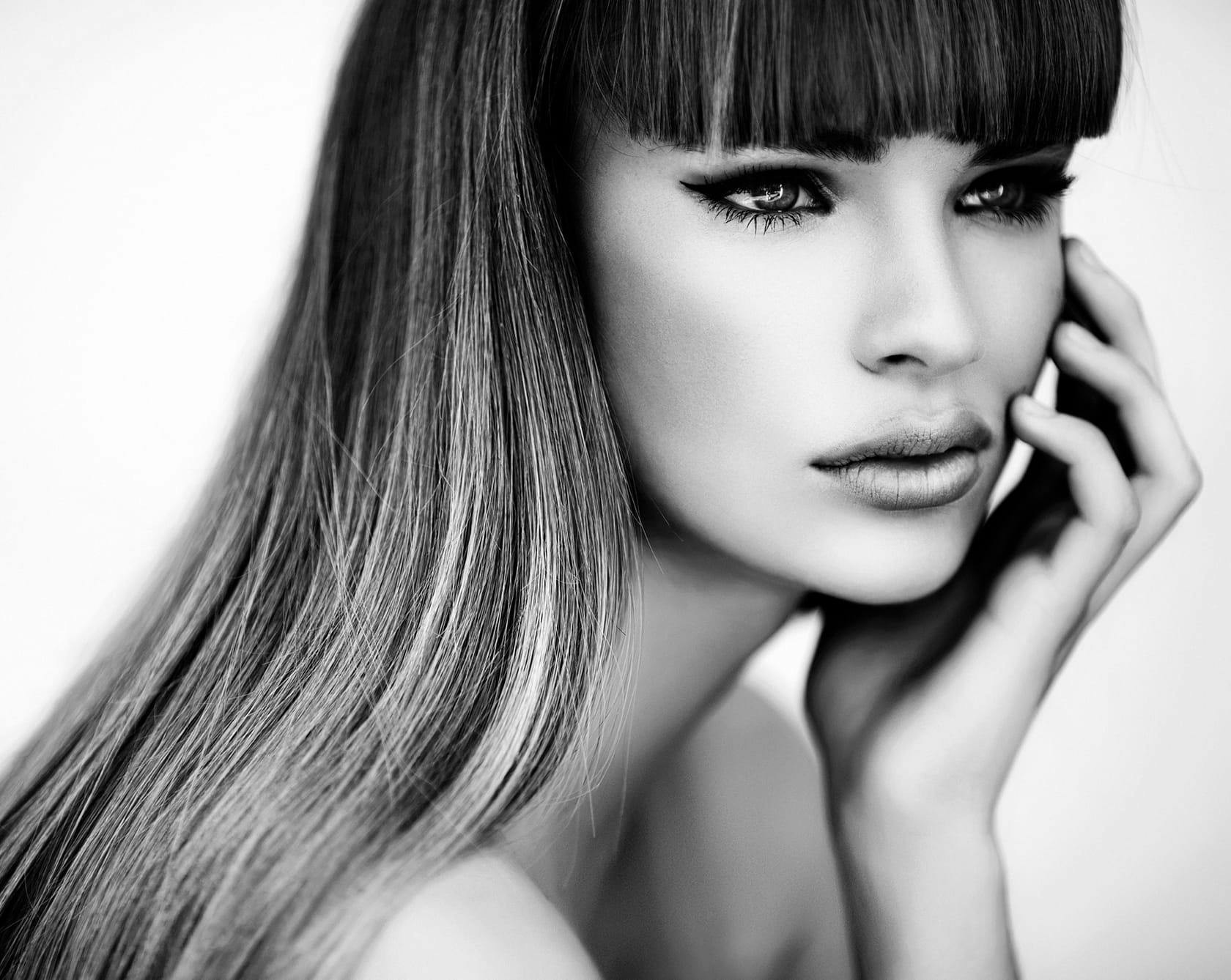 a black and white image of a woman with bangs