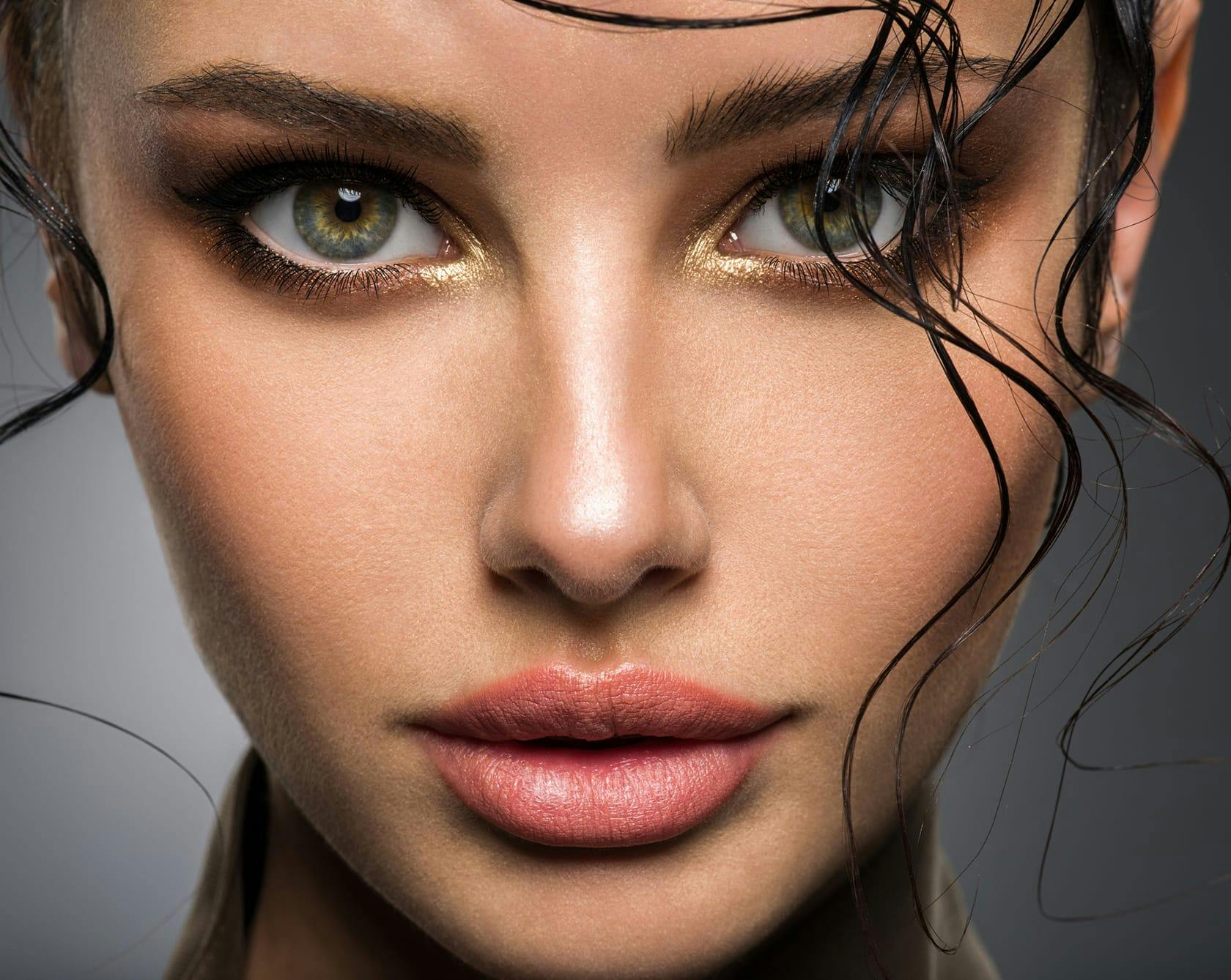 a close up image of a woman with green eyes and dark hair