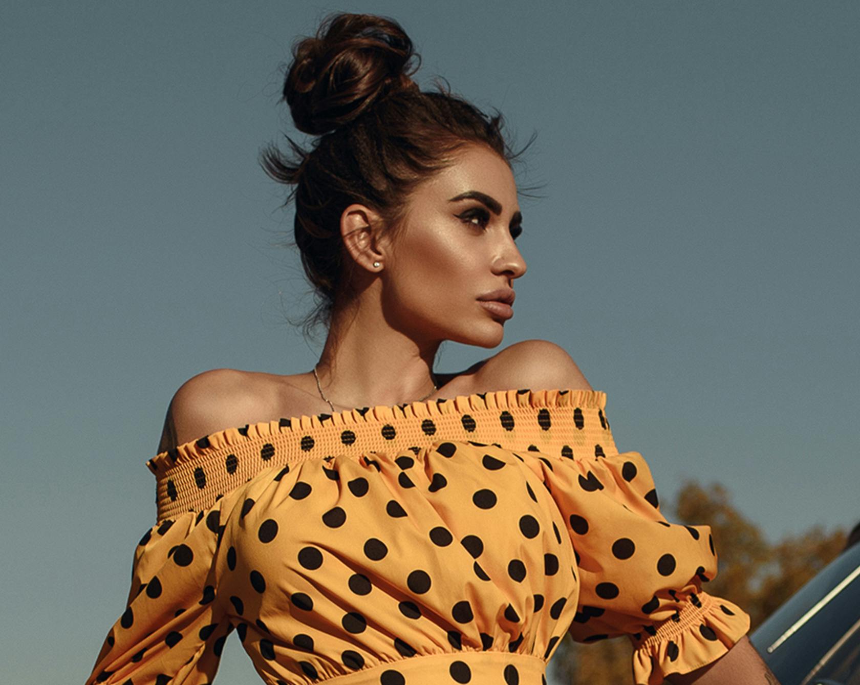 an image of a woman with dark hair in an orange poka-dot top